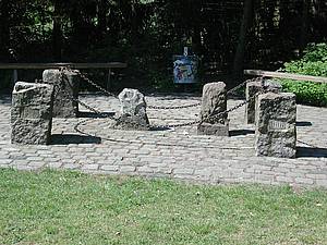 Die Prinzensteine in Südwinsen (2001) Mehrere steinerne Pfeiler, die in einem Kreis auf einer gepflasterten Fläche angeordnet sind und durch Metallketten verbunden sind. Im Hintergrund sind Bäume und eine Bank zu sehen. Im Vordergrund befindet sich eine Rasenfläche.